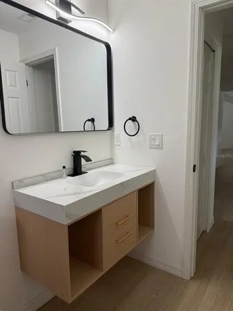 a bathroom with a sink vanity and mirror