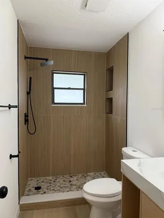 a bathroom with a granite countertop sink toilet and shower