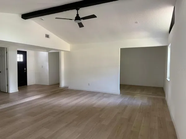 a view of an empty room with wooden floor