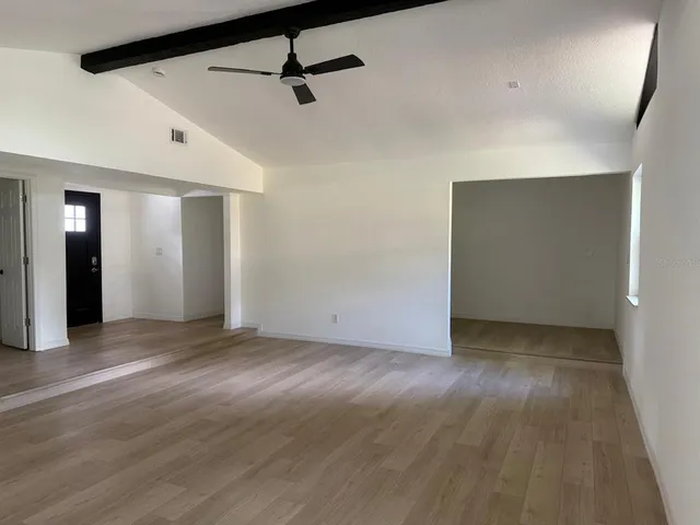 a view of an empty room with wooden floor