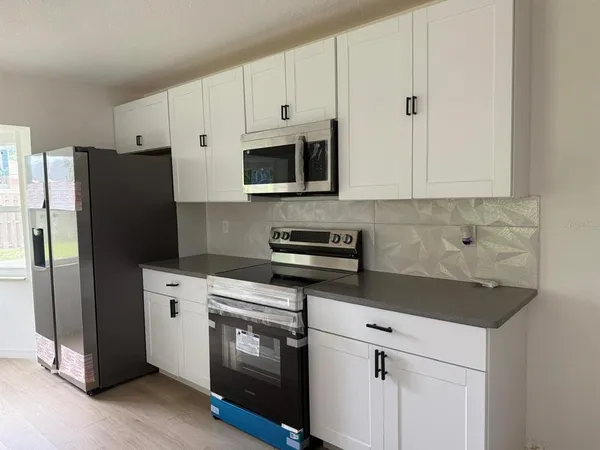 a kitchen with cabinets stainless steel appliances and a counter space