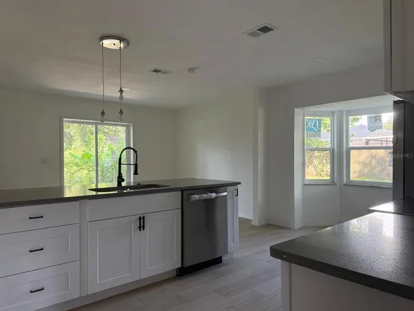 a kitchen with cabinets appliances and a window
