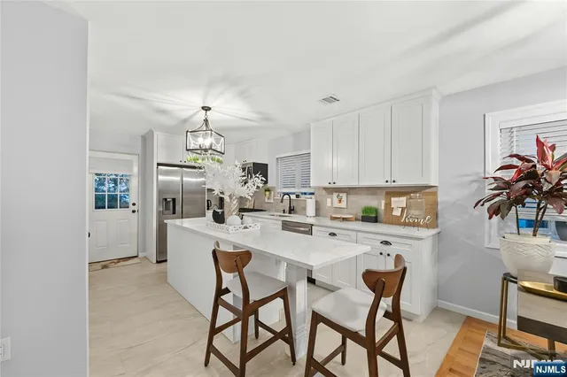 a kitchen with a dining table chairs and white cabinets