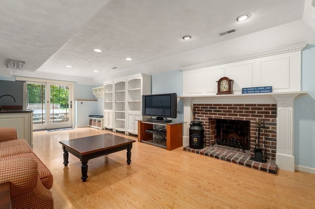 11 Equestrian Drive North Reading, MA 01864 - Photo 22 of 41 a living room with furniture a fireplace and a flat screen tv