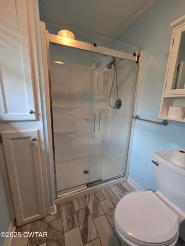 a bathroom with a toilet and a shower