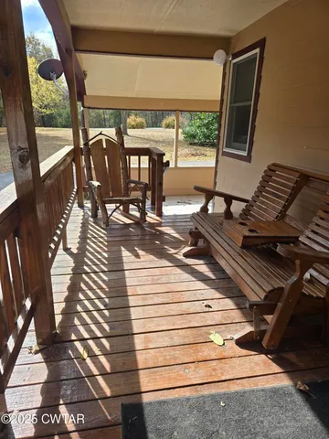 a view of a balcony with chairs and wooden floor