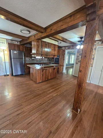 a kitchen with stainless steel appliances wooden floor