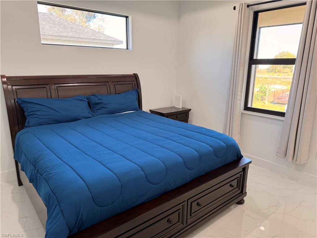 941 Columbus Boulevard Lehigh Acres, FL 33974 - Photo 10 of 41 a bed sitting in a bedroom next to a window