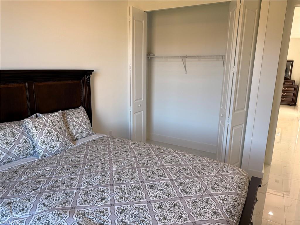 941 Columbus Boulevard Lehigh Acres, FL 33974 - Photo 14 of 41 a bedroom with a bed and a dresser