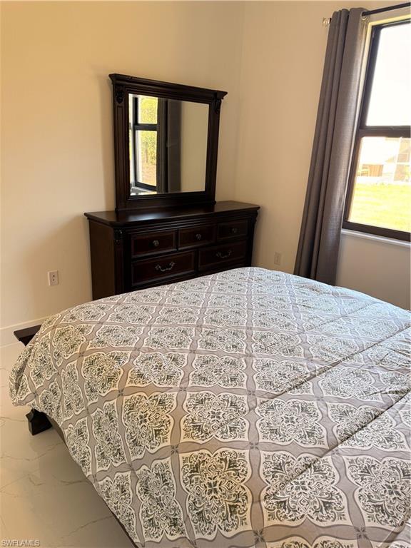 941 Columbus Boulevard Lehigh Acres, FL 33974 - Photo 18 of 41 a bed sitting in a bedroom next to a window