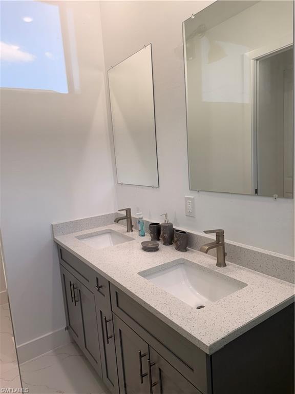 941 Columbus Boulevard Lehigh Acres, FL 33974 - Photo 27 of 41 a bathroom with a sink and a mirror