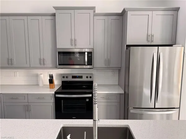 a kitchen with a refrigerator and a stove top oven