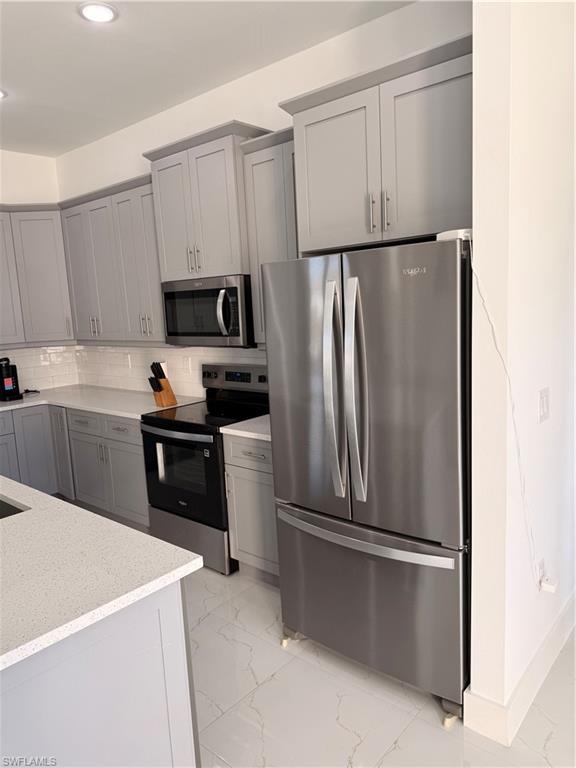 941 Columbus Boulevard Lehigh Acres, FL 33974 - Photo 34 of 41 a kitchen with a refrigerator sink and wooden cabinets
