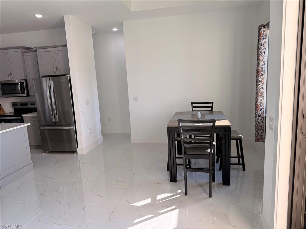 941 Columbus Boulevard Lehigh Acres, FL 33974 - Photo 35 of 41 a view of a kitchen with refrigerator and a stove