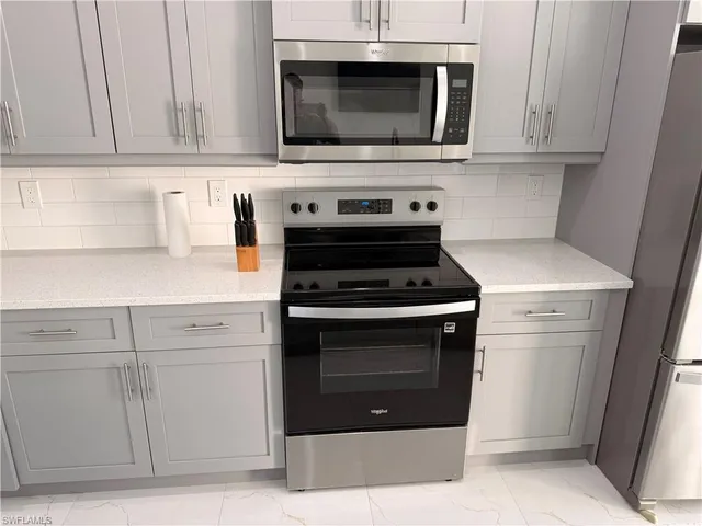 a kitchen with stainless steel appliances granite countertop a stove microwave and cabinets