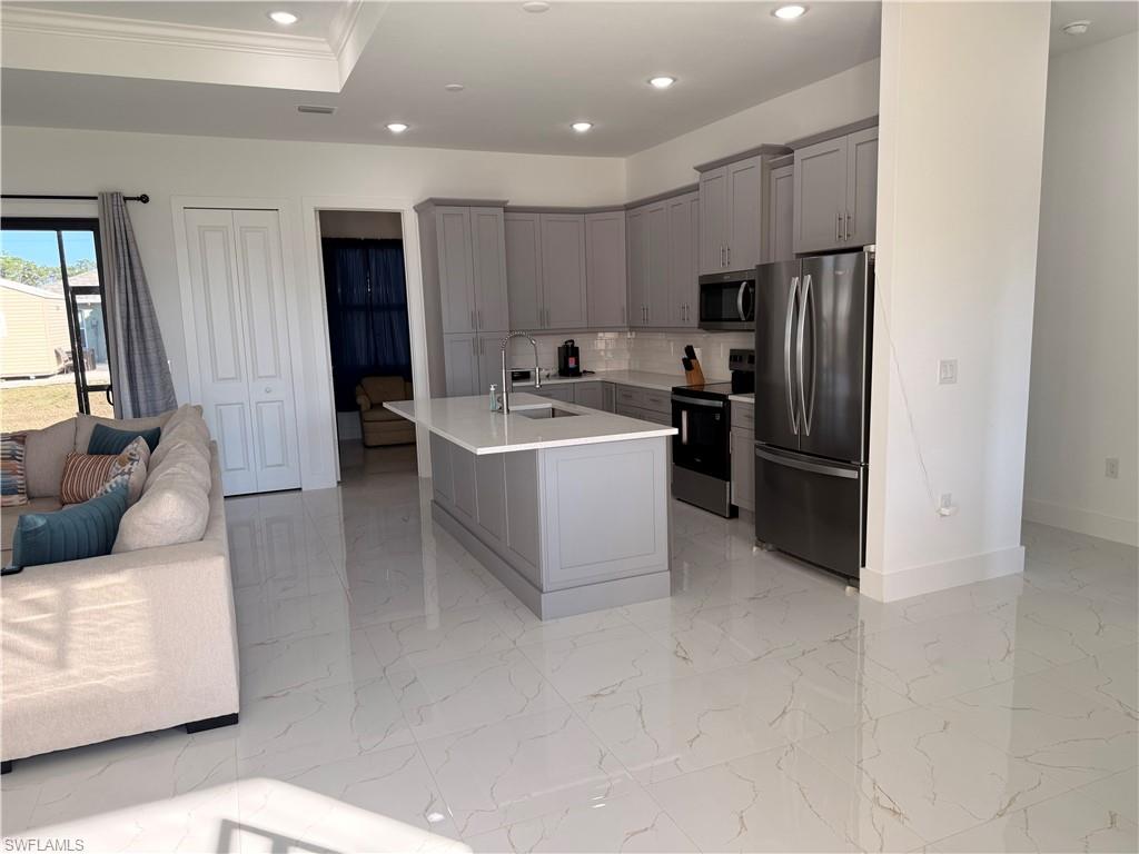 941 Columbus Boulevard Lehigh Acres, FL 33974 - Photo 39 of 41 a living room with stainless steel appliances furniture a refrigerator and a kitchen sink
