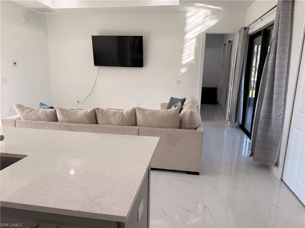 a living room with furniture and a refrigerator