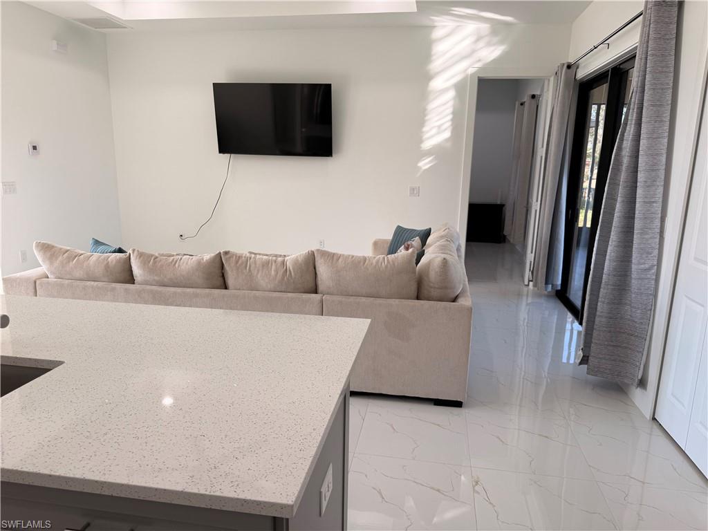 941 Columbus Boulevard Lehigh Acres, FL 33974 - Photo 6 of 41 a living room with furniture and a flat screen tv