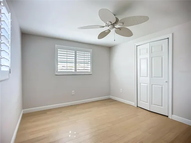 an empty room with a window and a fan