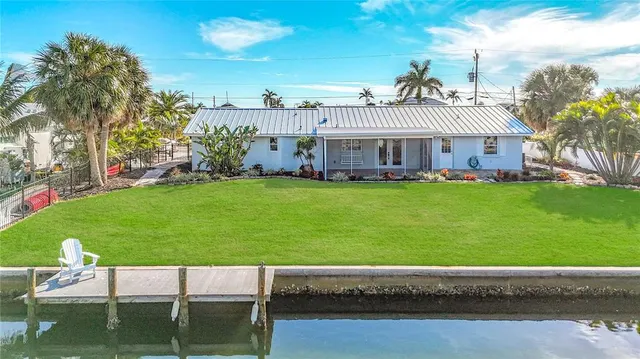 a view of a house with a big yard and sitting area