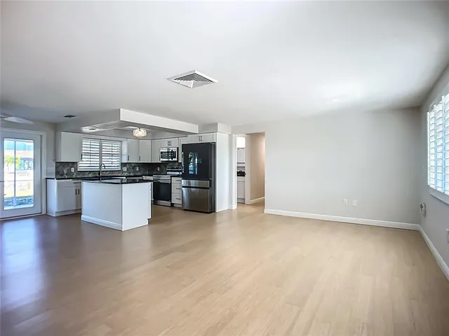 a kitchen with stainless steel appliances kitchen island granite countertop a stove sink and cabinets