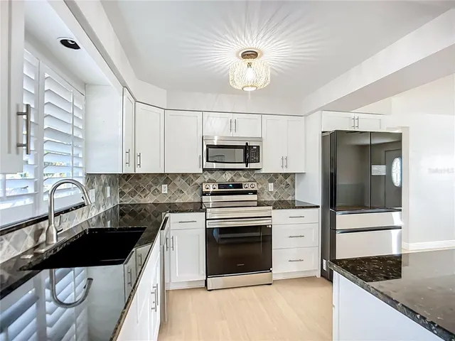 a kitchen with stainless steel appliances granite countertop a sink and cabinets