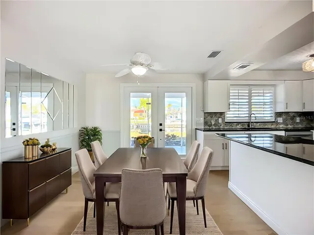 a living room with furniture a large window and a dining table