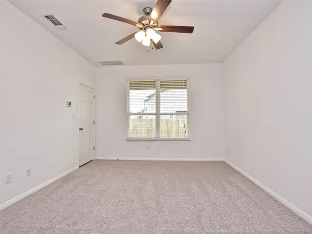 an empty room with a window and a fan