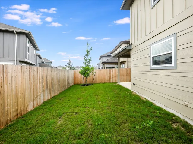 a view of a backyard with plants and wooden fence