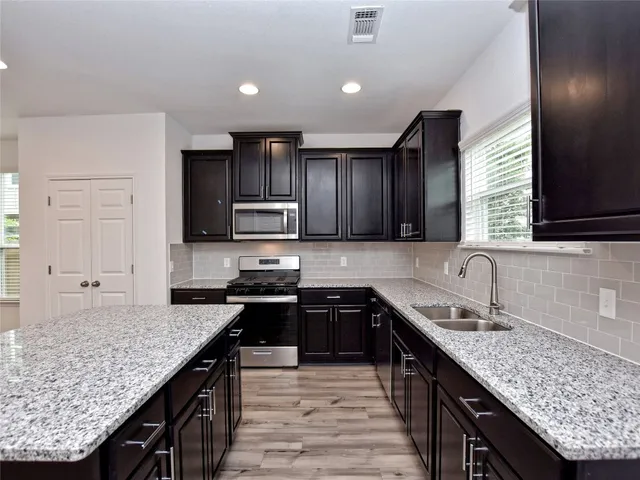 a kitchen with stainless steel appliances granite countertop counter space a sink and cabinets