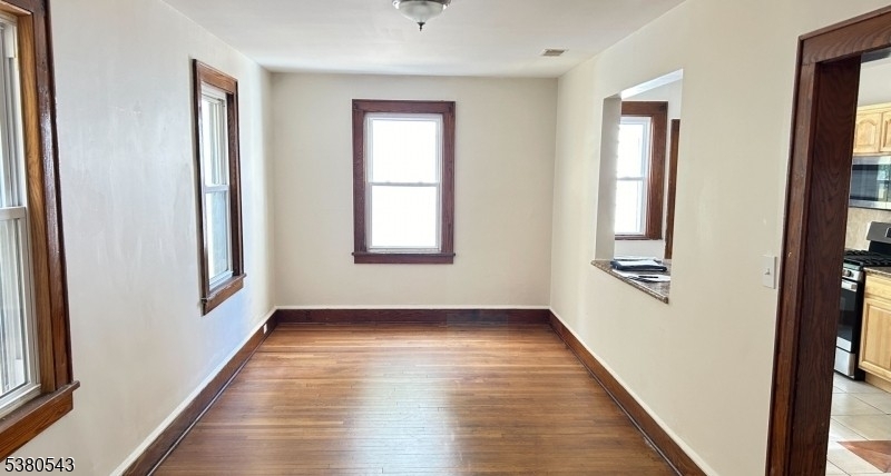 63 Maple Avenue Irvington, NJ 07111 - Photo 19 of 28 a view of an empty room with wooden floor and a window