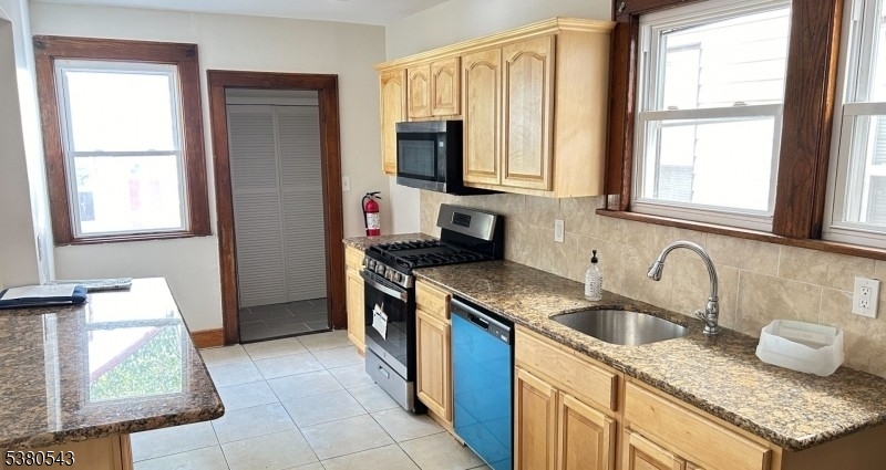 63 Maple Avenue Irvington, NJ 07111 - Photo 20 of 28 a kitchen with granite countertop a sink and a stove top oven