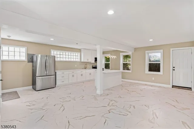 a view of a refrigerator in kitchen and livingroom with furniture