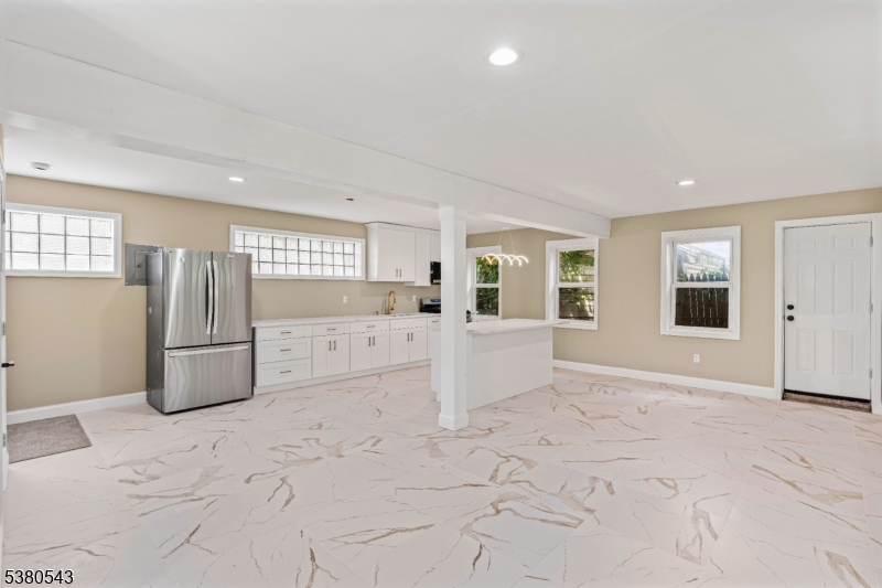 63 Maple Avenue Irvington, NJ 07111 - Photo 2 of 28 a view of a refrigerator in kitchen and livingroom with furniture