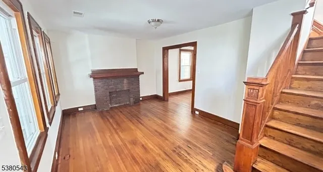 an empty room with wooden floor and a window