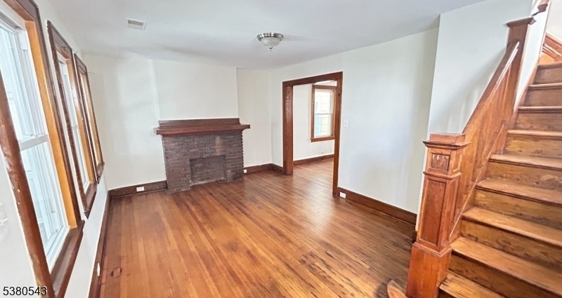 63 Maple Avenue Irvington, NJ 07111 - Photo 21 of 28 an empty room with wooden floor and a window