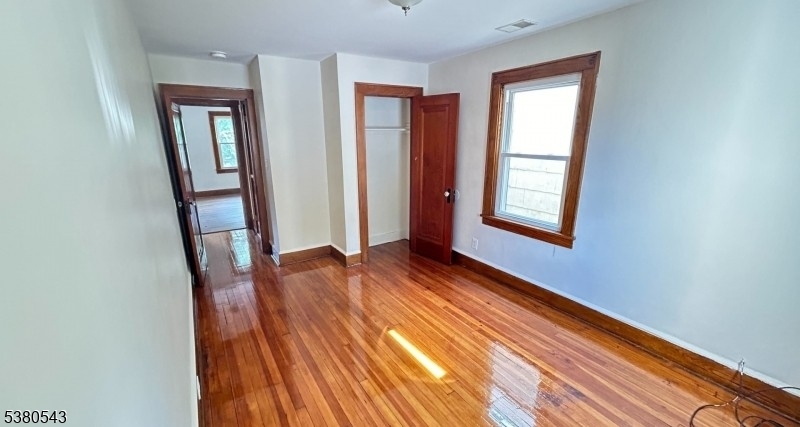 63 Maple Avenue Irvington, NJ 07111 - Photo 24 of 28 a view of an empty room with wooden floor and a window