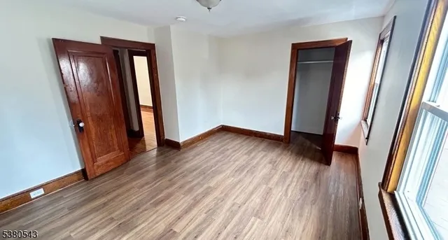 an empty room with wooden floor and entrance