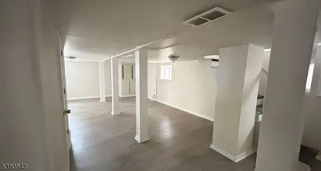 an empty room with wooden floor and a bathroom