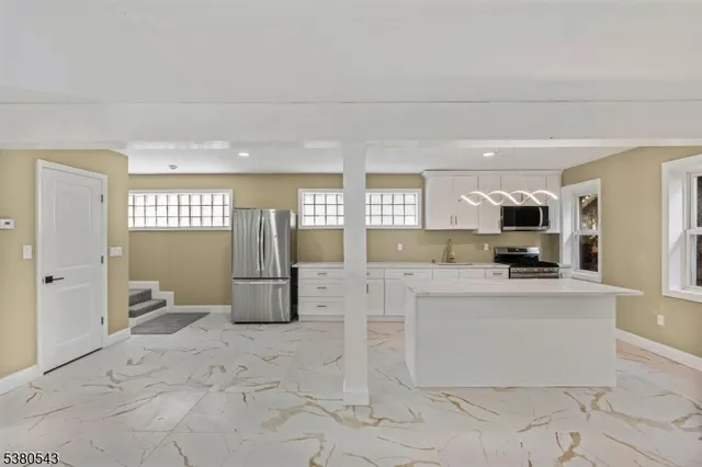 a large white kitchen with cabinets