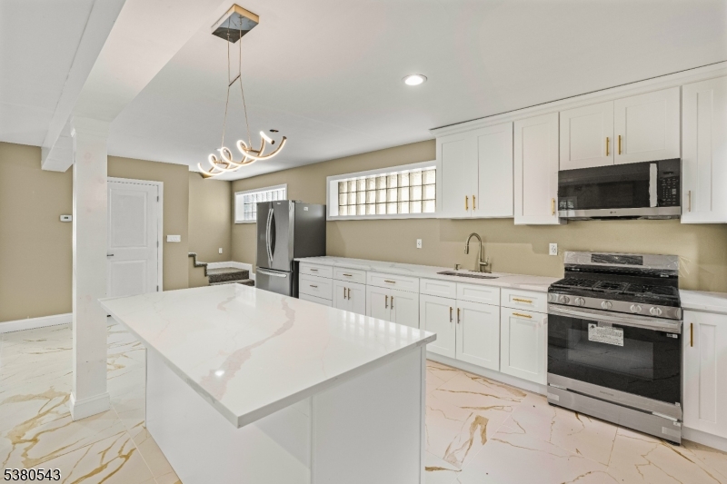 63 Maple Avenue Irvington, NJ 07111 - Photo 9 of 28 a kitchen with a stove a sink and a refrigerator