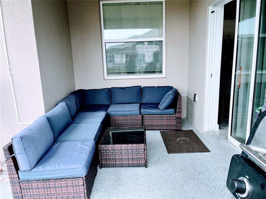 11498 Rhyme Avenue Orlando, FL 32832 - Photo 16 of 17 a living room with a couch and a dresser next to a window