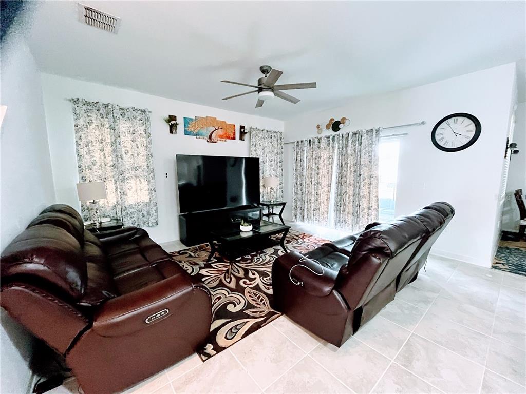 11498 Rhyme Avenue Orlando, FL 32832 - Photo 4 of 17 a living room with furniture a flat screen tv and a window