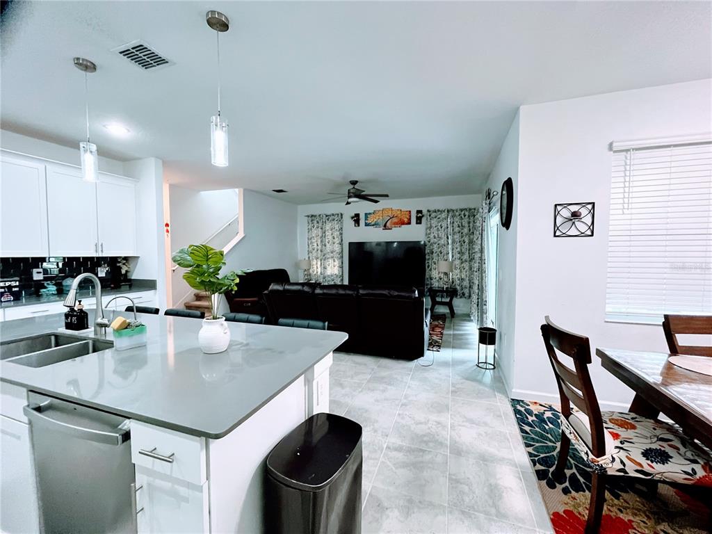11498 Rhyme Avenue Orlando, FL 32832 - Photo 6 of 17 a kitchen with a table chairs stove and refrigerator