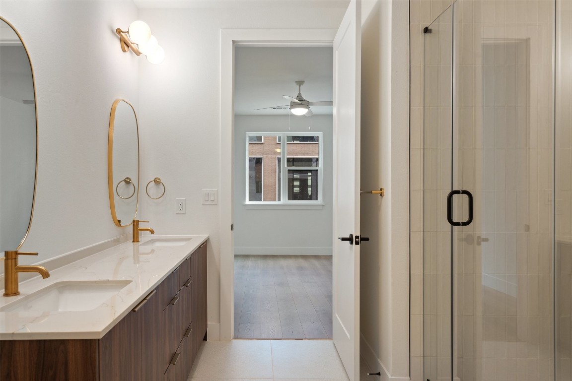 1701 Simond Avenue, Unit 206 Austin, TX 78723 - Photo 12 of 37 a bathroom with a double vanity sink a mirror and a shower