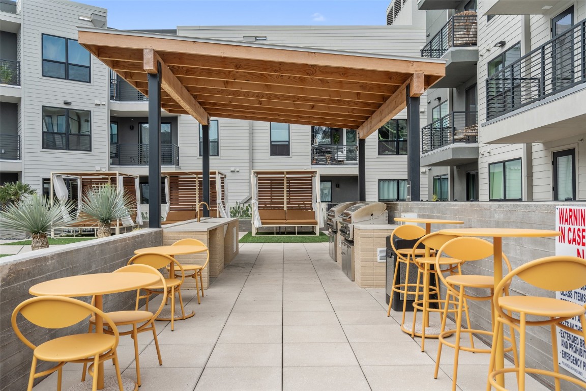 1701 Simond Avenue, Unit 206 Austin, TX 78723 - Photo 20 of 37 a view of a patio with table and chairs with wooden floor and plants