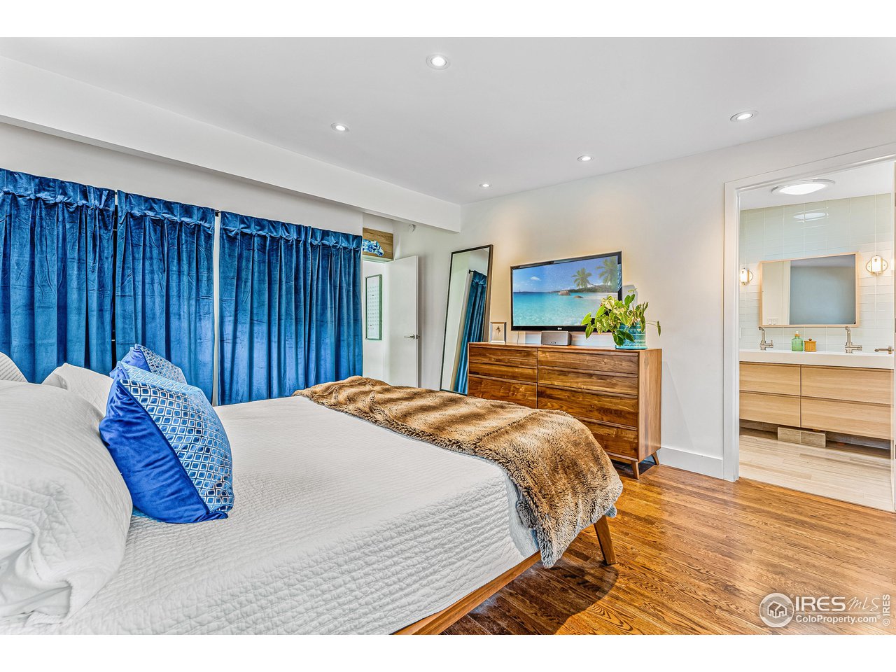 3560 9th Street Boulder, CO 80304 - Photo 24 of 39 a bedroom with a bed and a large mirror