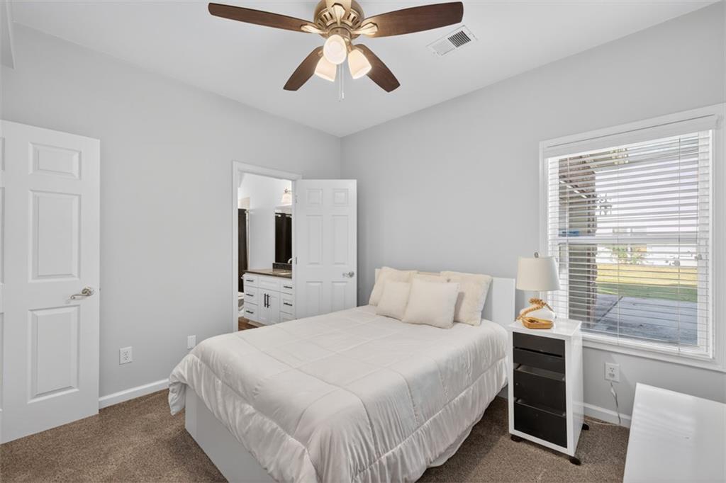 236 Reece Drive Hoschton, GA 30548 - Photo 19 of 58 a bedroom with a bed and a chandelier