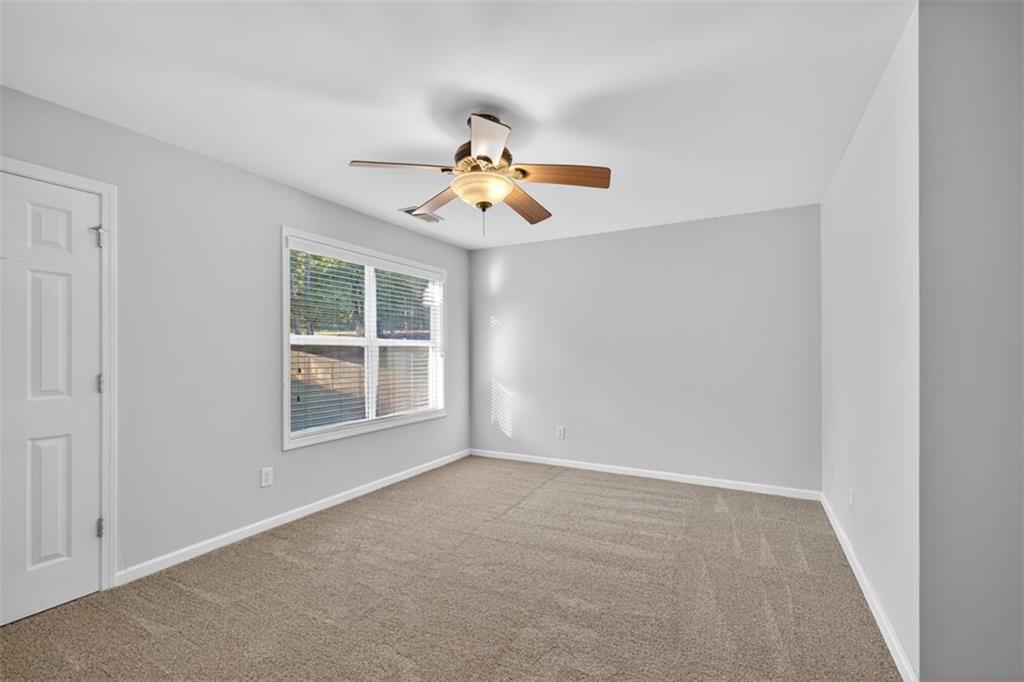 236 Reece Drive Hoschton, GA 30548 - Photo 25 of 58 an empty room with windows and chandelier fan