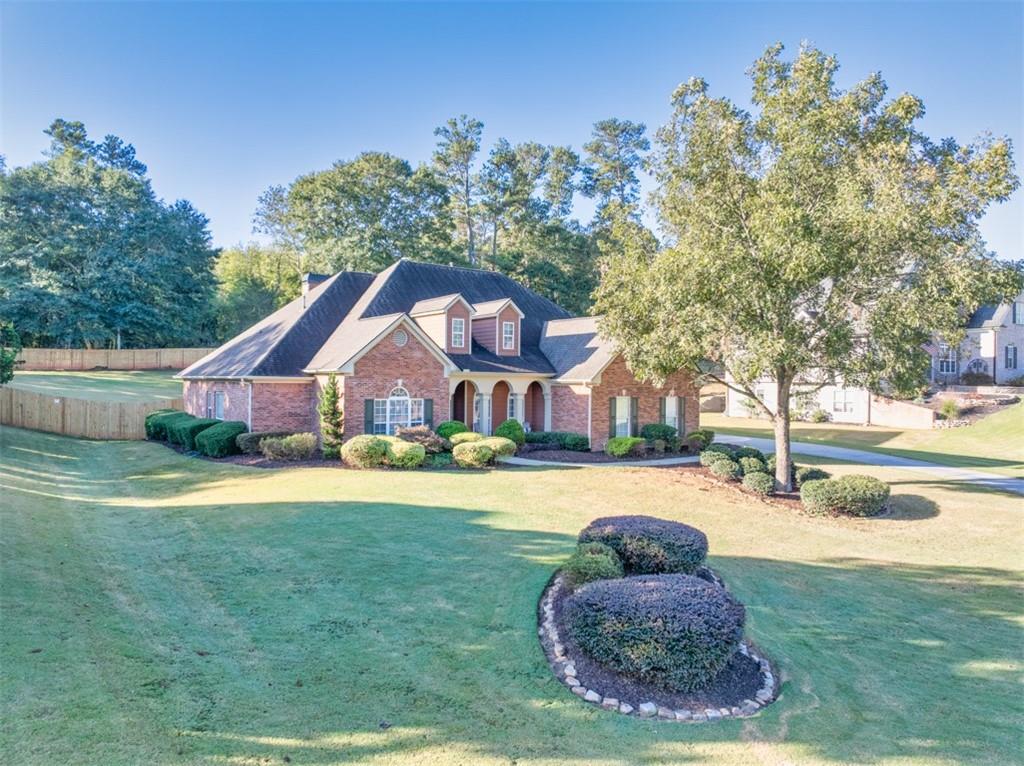 236 Reece Drive Hoschton, GA 30548 - Photo 39 of 58 a front view of a house with a garden and trees